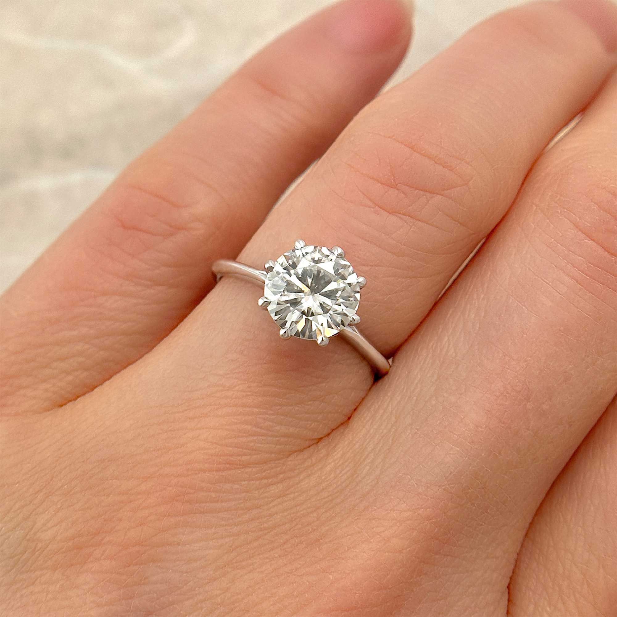 8 prong solitaire engagement ring on finger