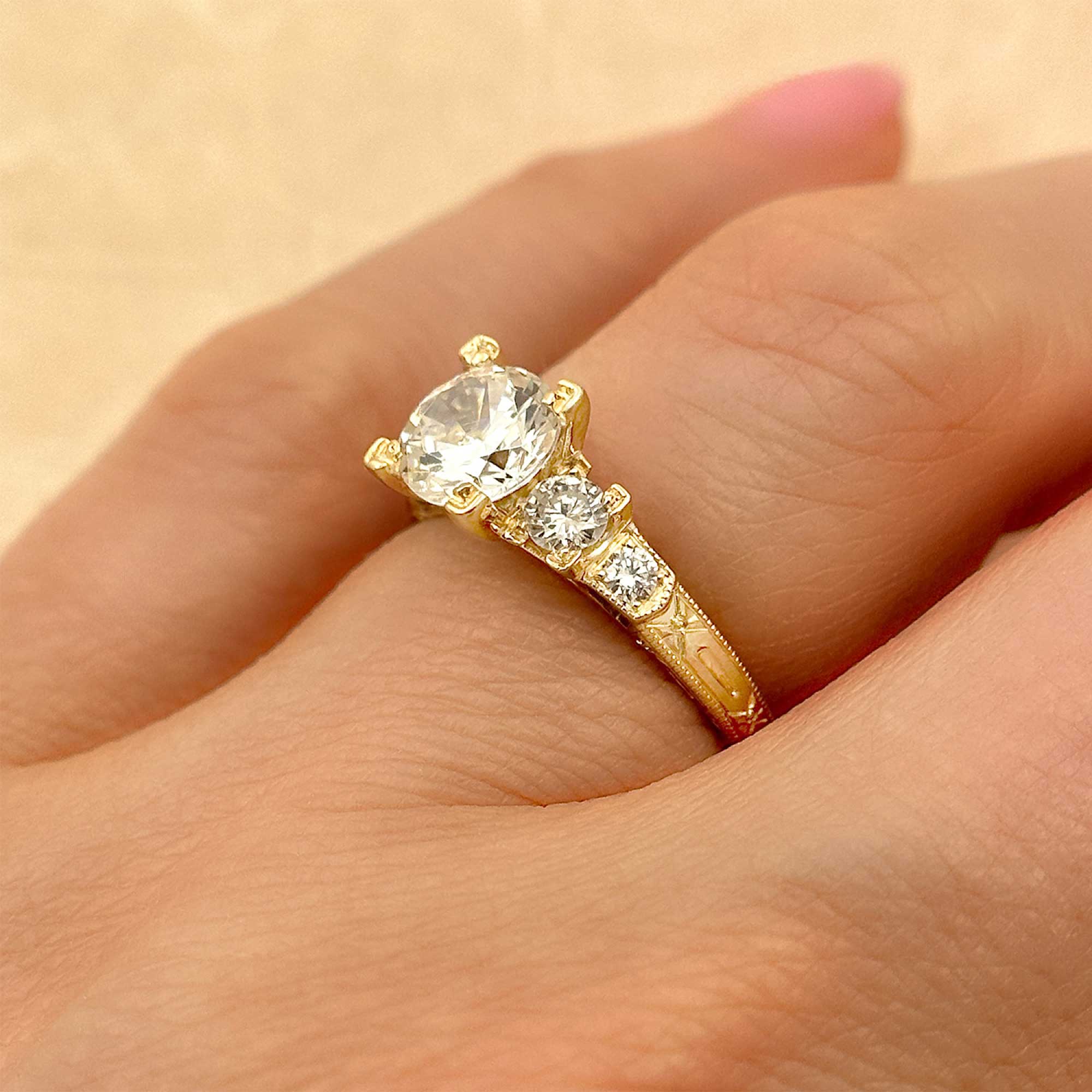 hand engraved round diamond stepped engagement ring on finger