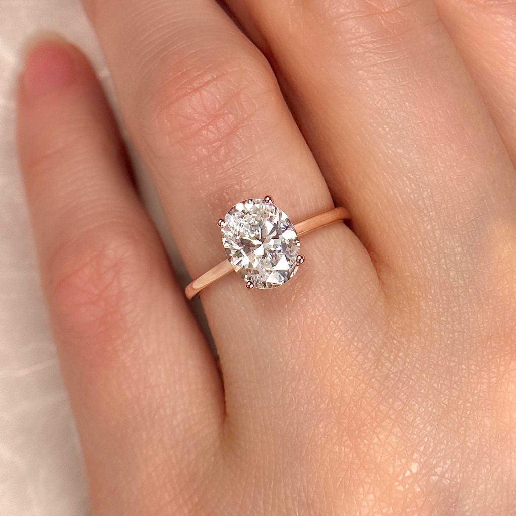 oval solitaire engagement ring rose gold on finger alt view