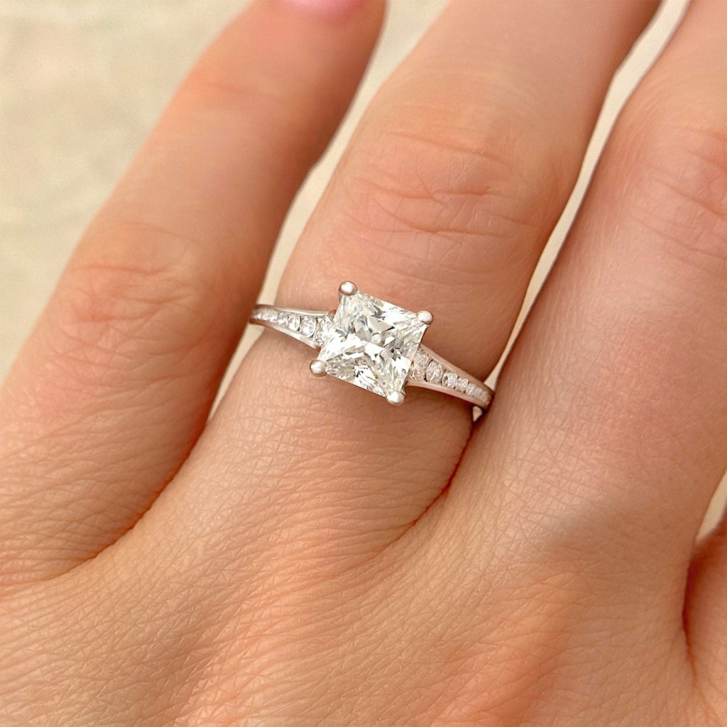 princess cut diamond engagement ring with channel accents on finger alt view