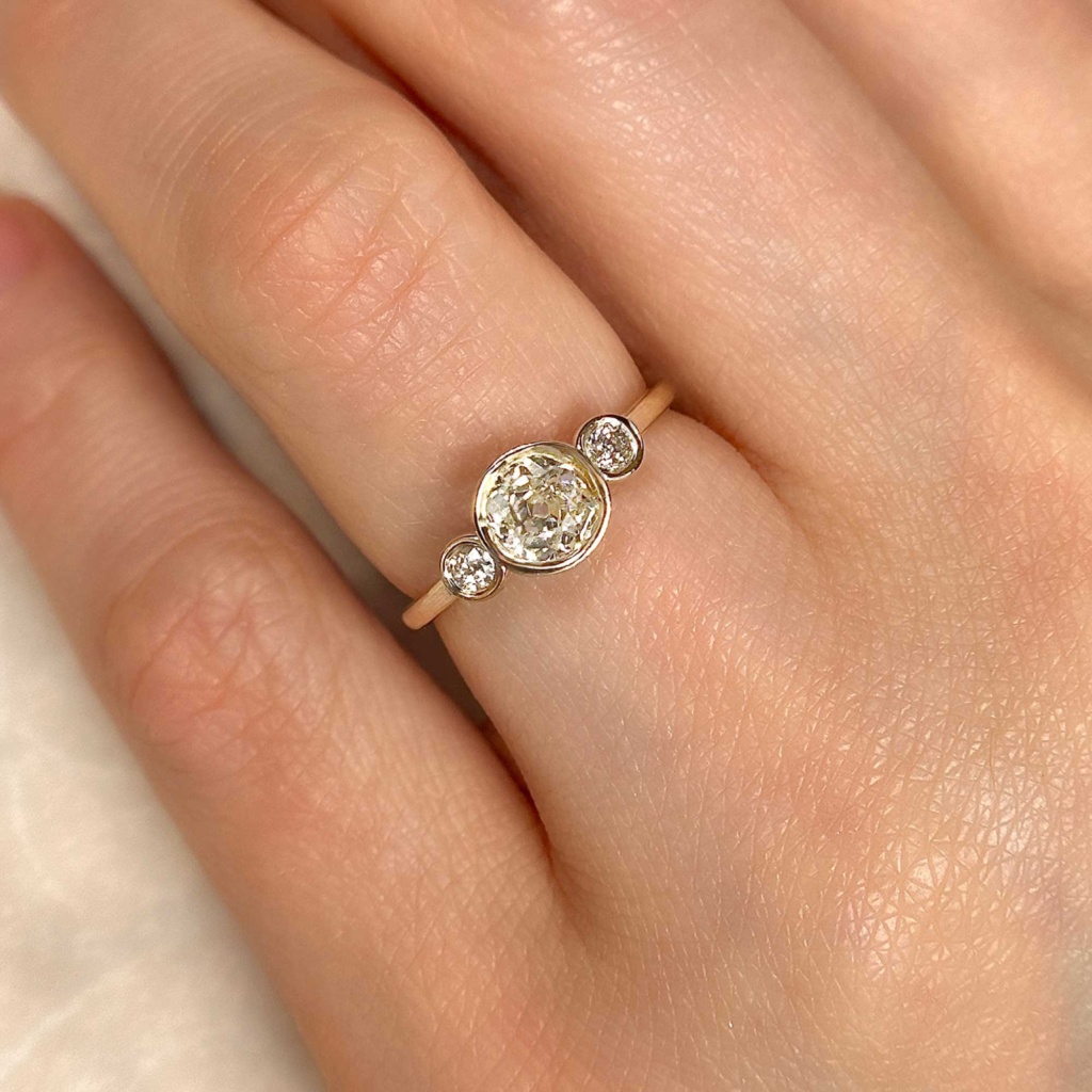 three bezel set old european cut engagement ring on finger