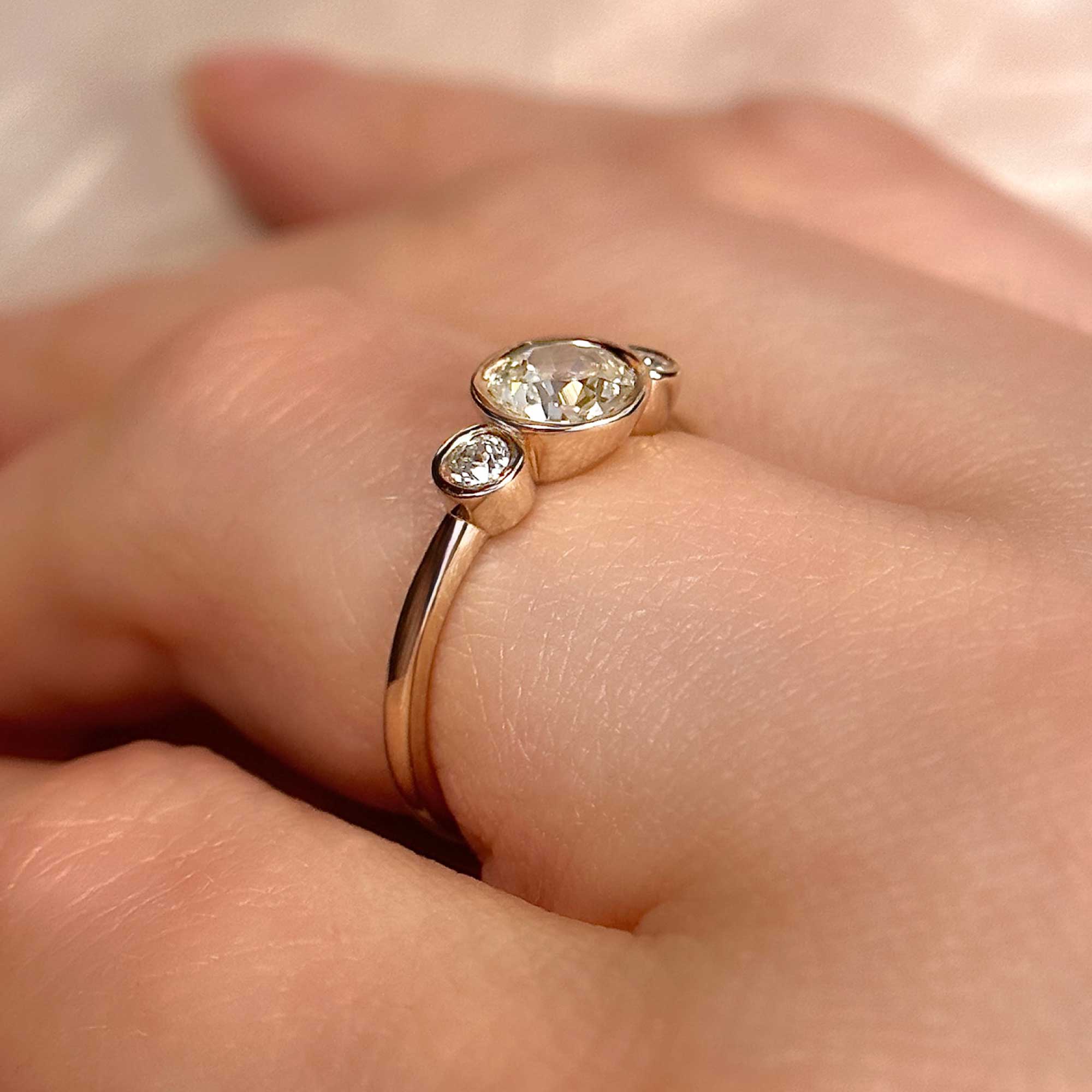 three bezel set old european cut engagement ring on finger alt view