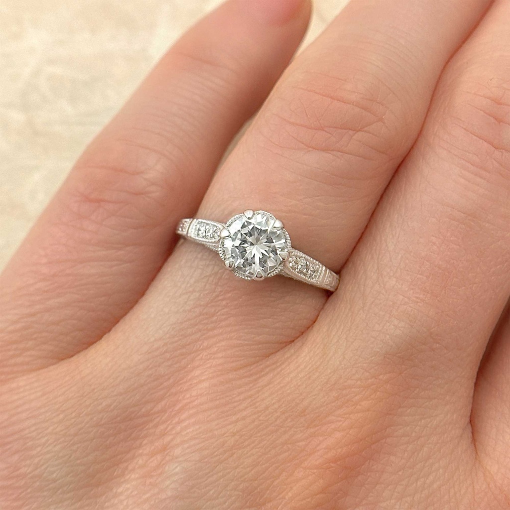 vintage style diamond engagement ring with diamond pave accents on finger
