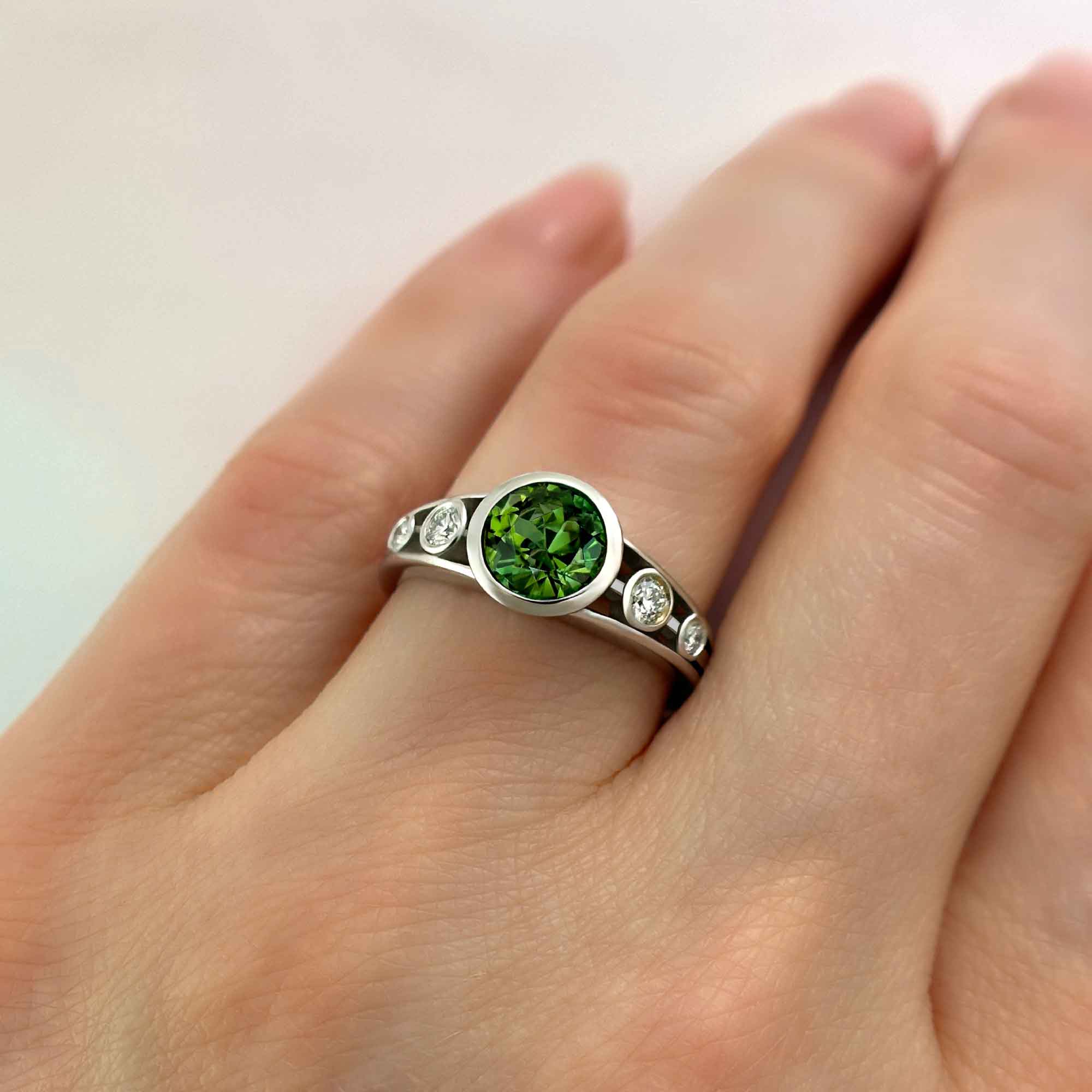green tourmaline and diamond ring on hand